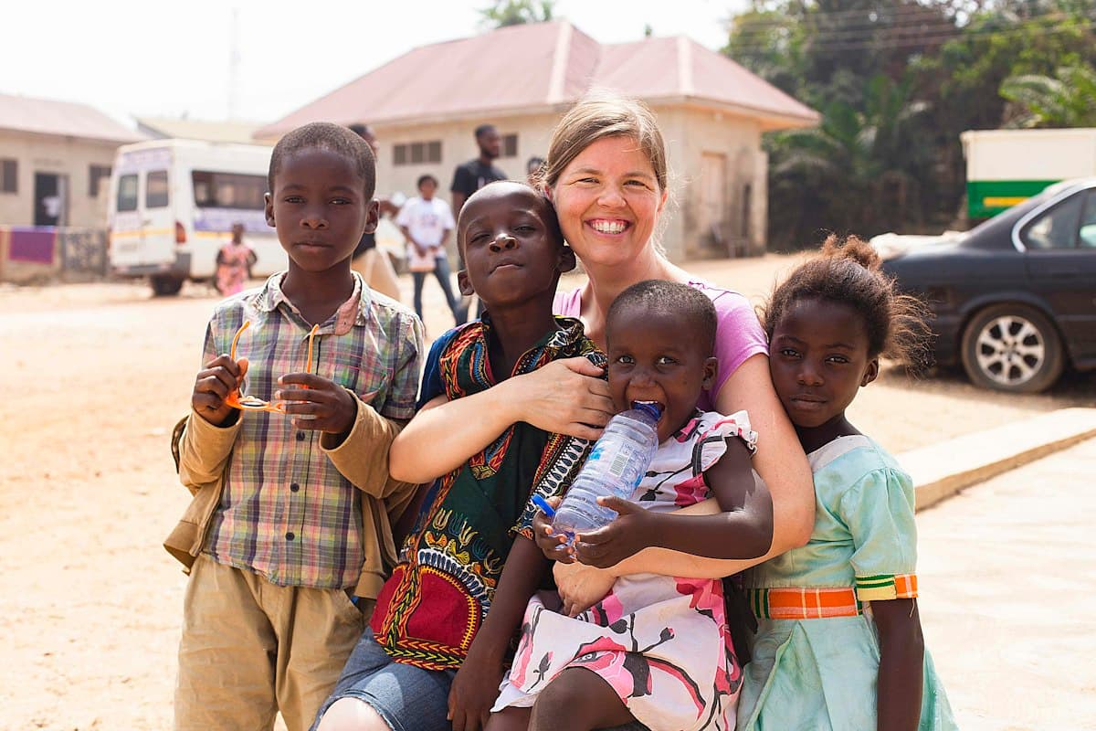 An LCF volunteer with children from the community